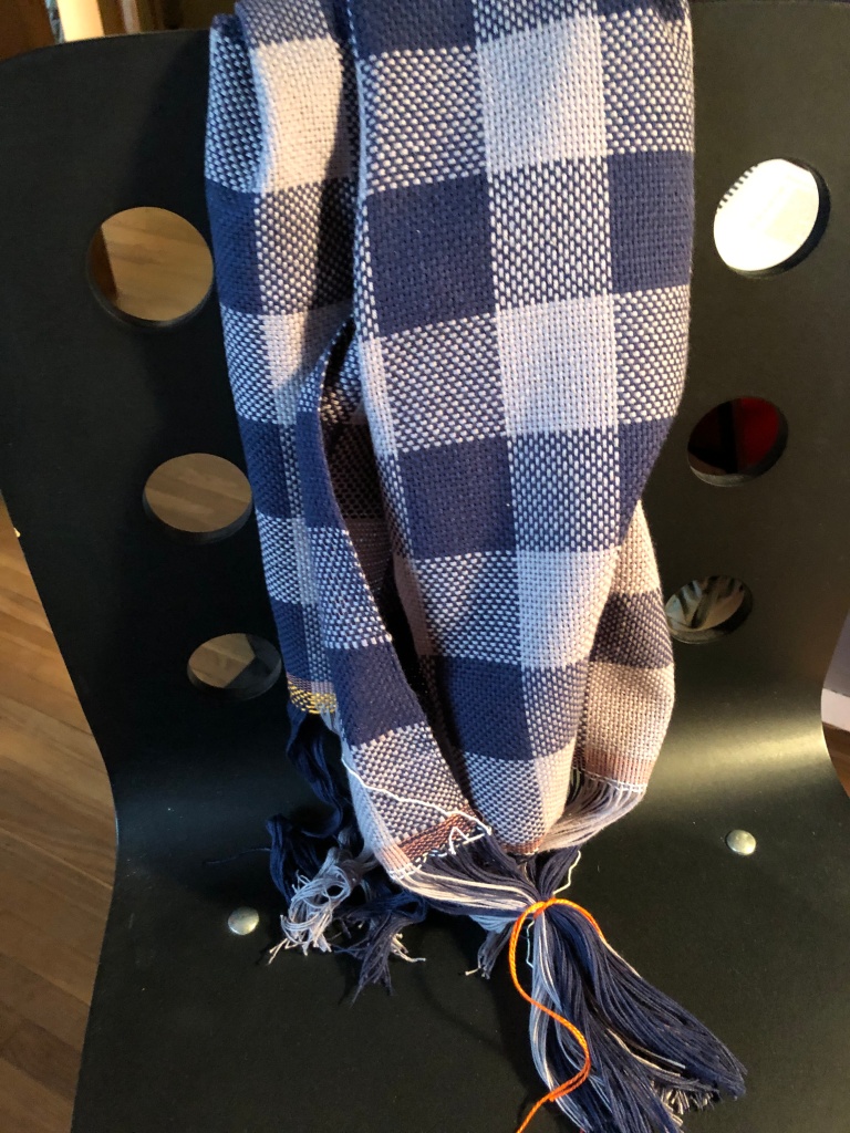 blue and gray checked cloth draped over a chair